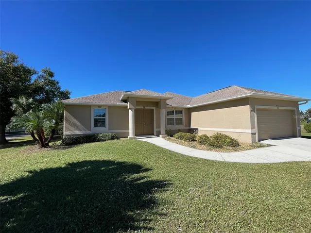 a front view of a house with a garden and yard