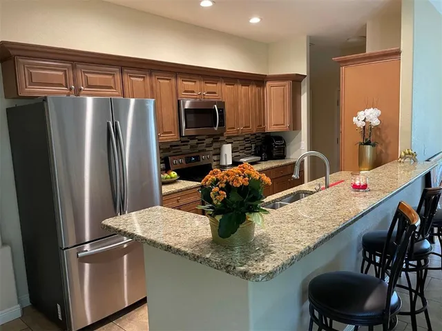 a kitchen with stainless steel appliances granite countertop a sink refrigerator and microwave