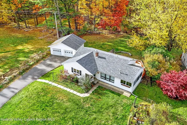 an aerial view of a house with a big yard and large trees