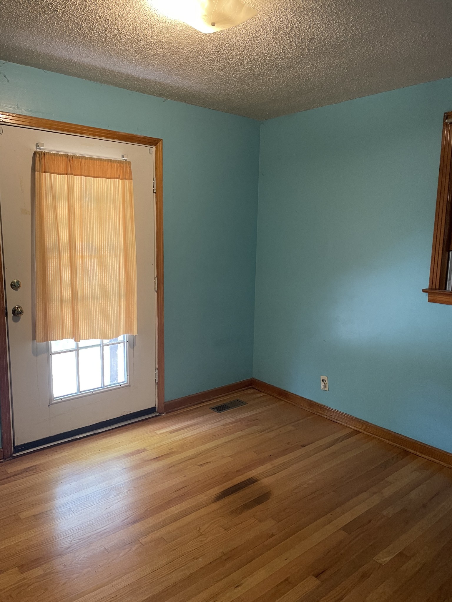 2004 Post Road Clarksville, TN 37043 - Photo 11 of 16 an empty room with wooden floor and windows with curtains