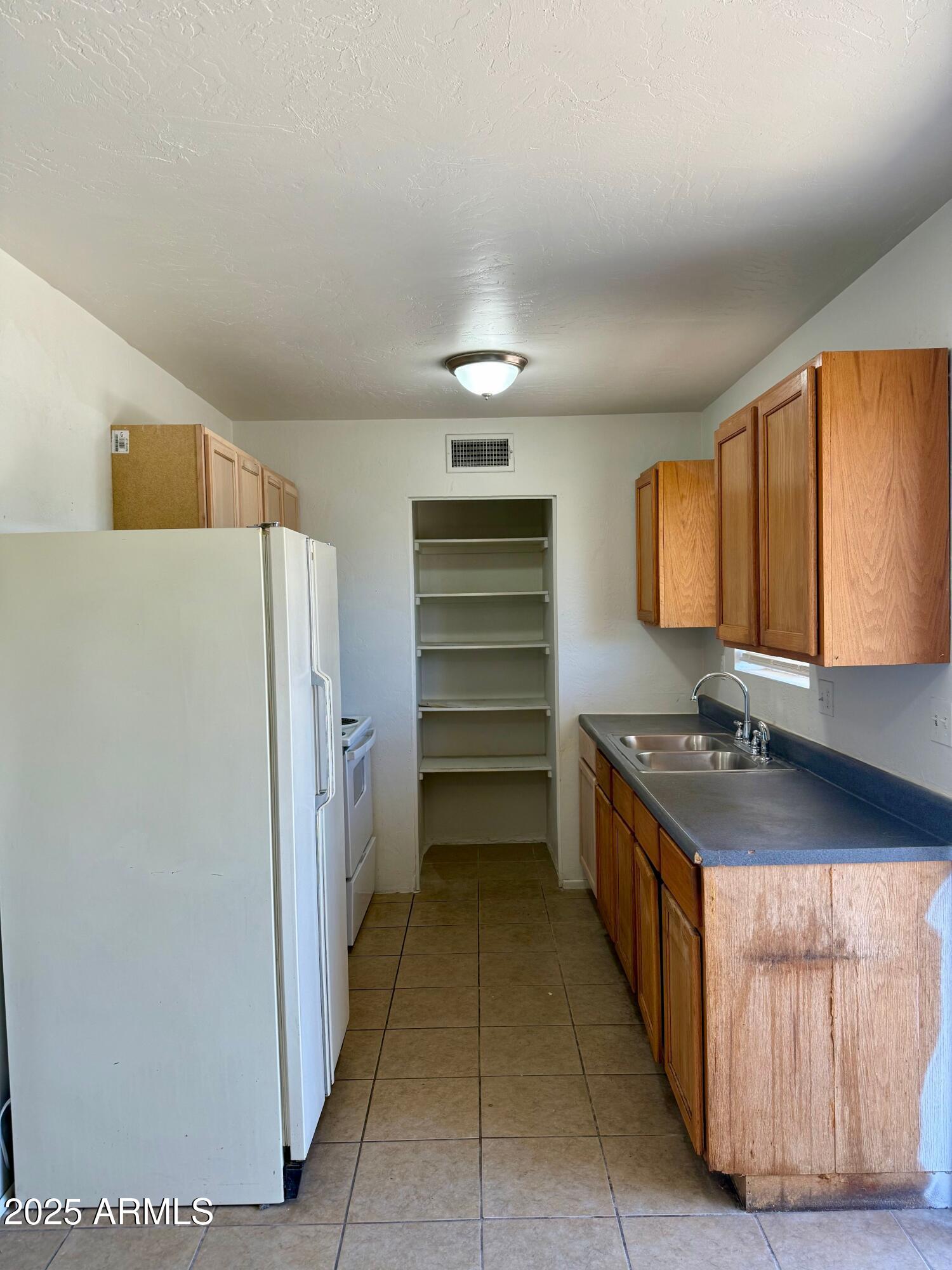 28 West Elm Street Tucson, AZ 85705 - Photo 6 of 14 a kitchen with a refrigerator and a sink