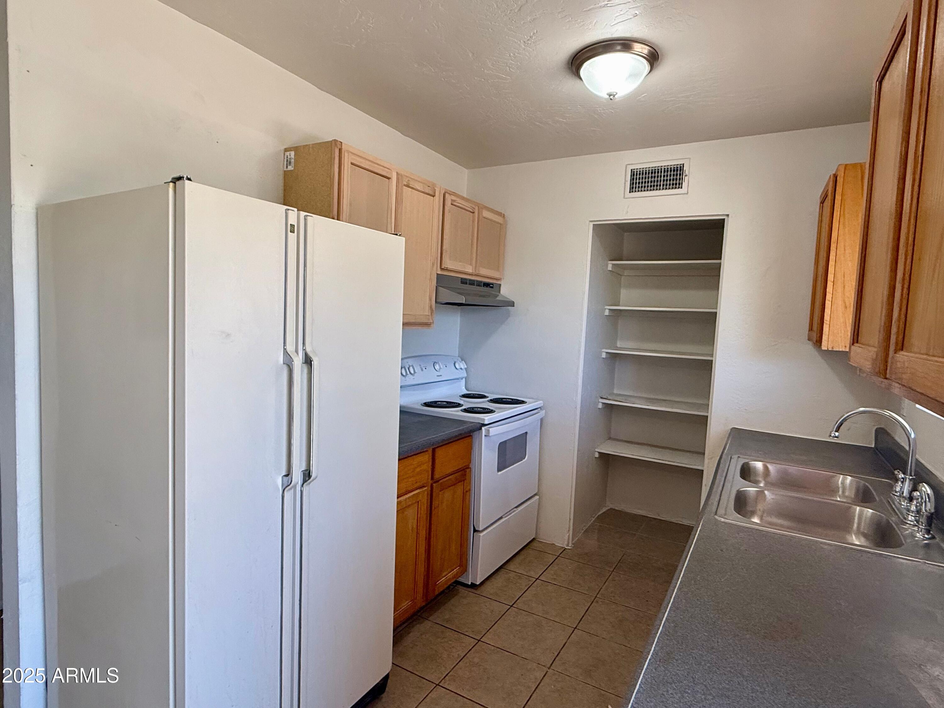 28 West Elm Street Tucson, AZ 85705 - Photo 7 of 14 a kitchen with stainless steel appliances a refrigerator and a sink