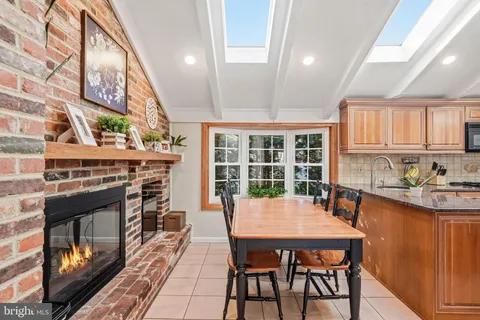 a dining room with furniture a fireplace and large windows