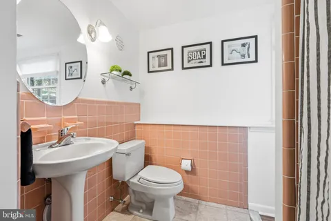 a view of a patio with couches table and chairs under an umbrella with wooden floor