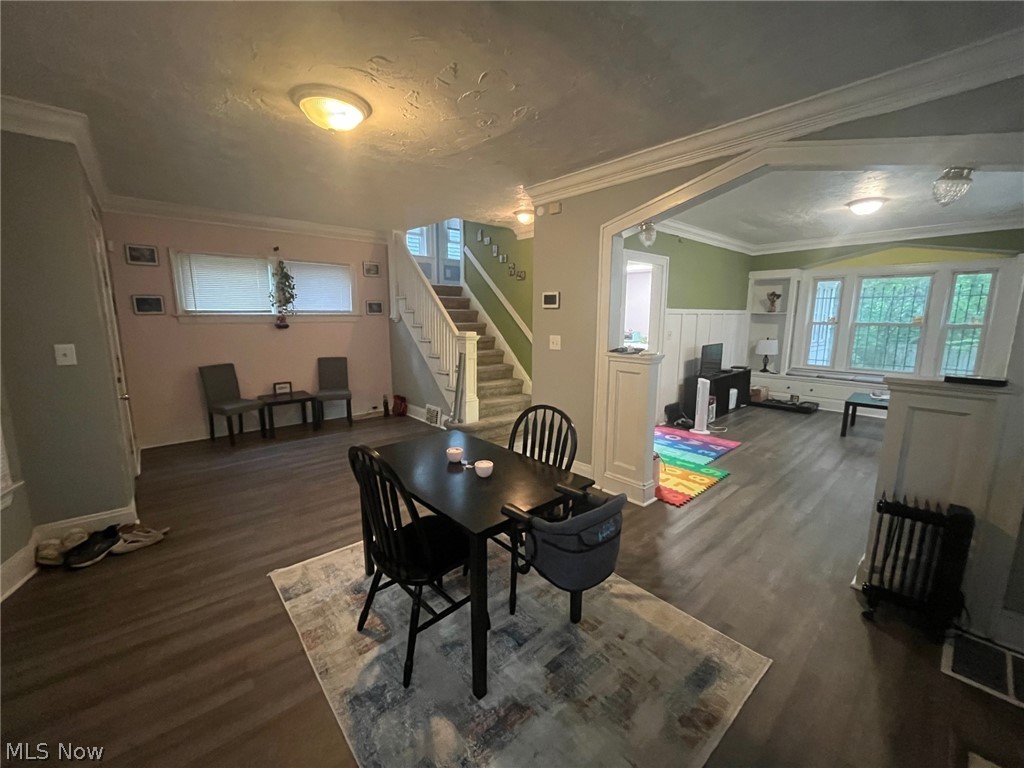 1101 Carlyon Road East Cleveland, OH 44112 - Photo 4 of 23 Spacious interior featuring new flooring, a carpeted staircase, and crown molding. Family room opens into the dining room.