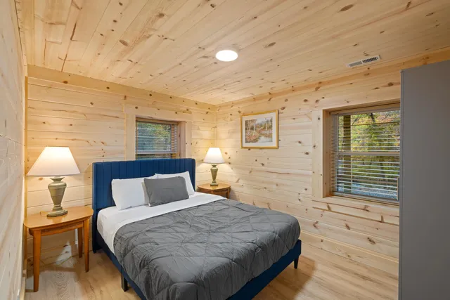 a bedroom with a bed and a lamp on dresser