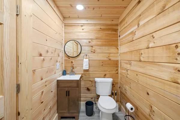 a bathroom with a toilet sink vanity and granite