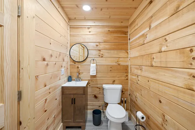 a bathroom with a toilet sink vanity and granite