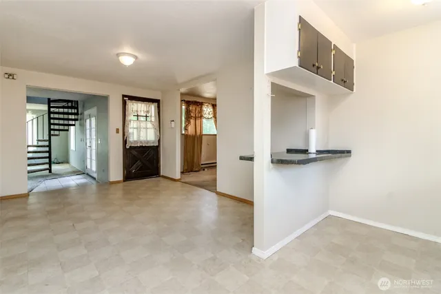 an entryway of a house and hallway with chandelier