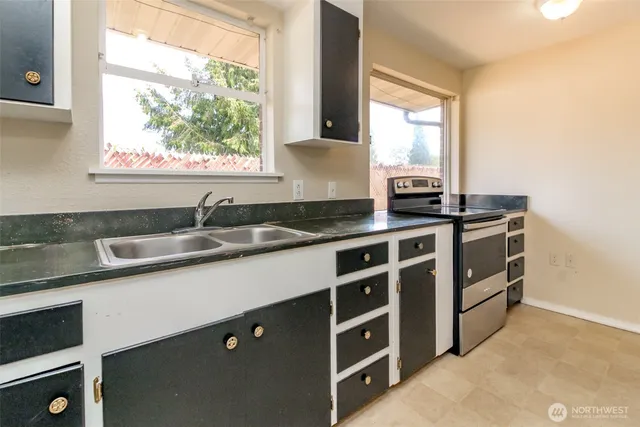 a kitchen with stainless steel appliances a sink stove and window