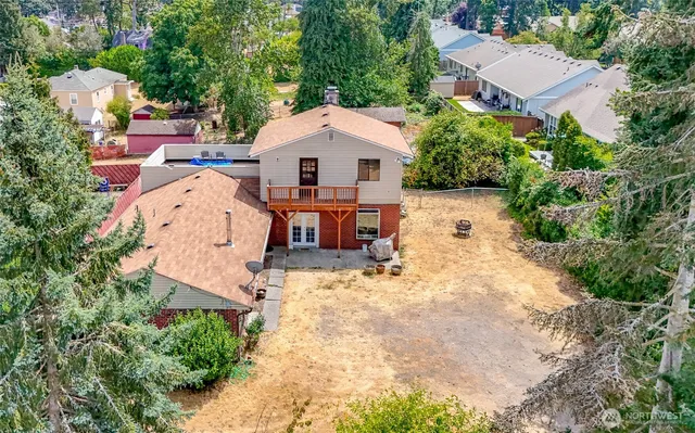 an aerial view of a house with outdoor space and trees all around