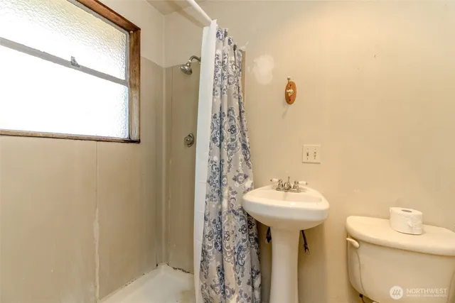 a bathroom with a toilet a sink and a window