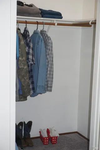 a view of walk in closet with clothes and shoes