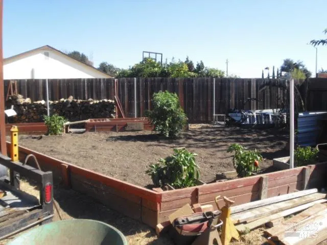 a view of backyard with seating space and wooden fence