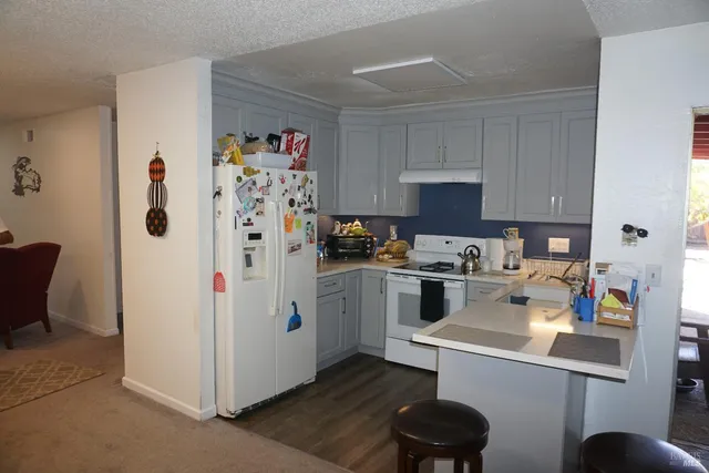 a kitchen with a refrigerator and a stove top oven