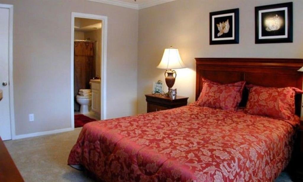a large bed sitting in a bedroom next to a lamp
