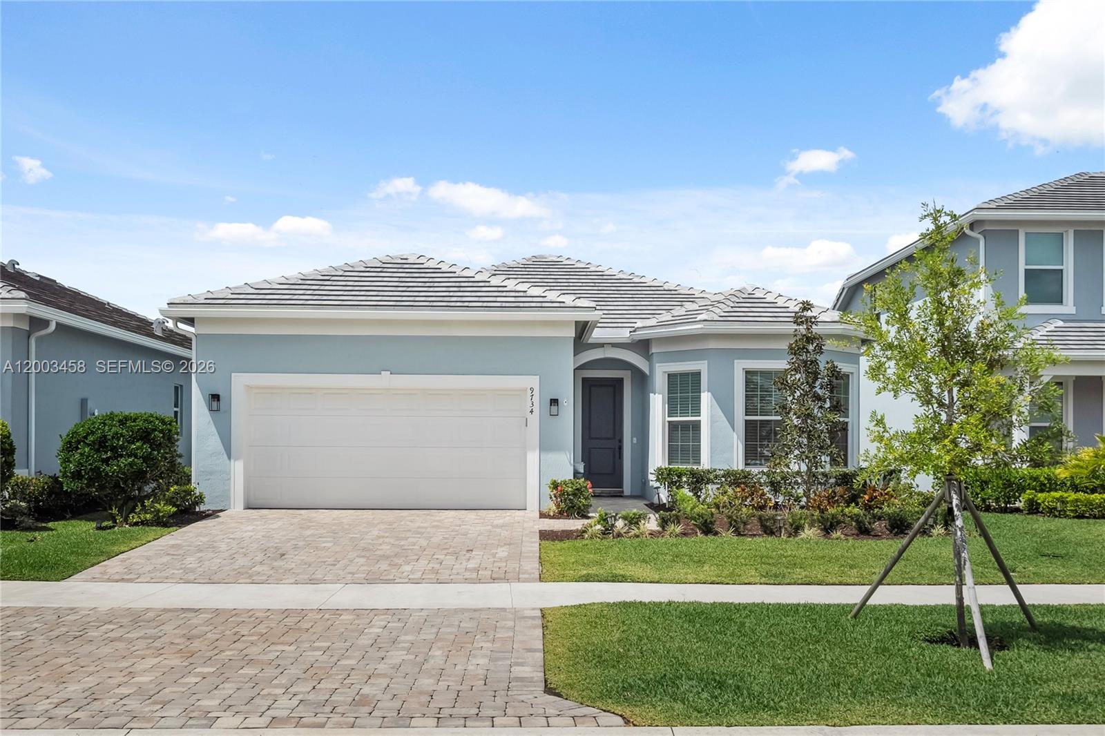 9734 Southwest Meridian Way Stuart, FL 34997 - Photo 1 of 48 a front view of a house with a yard and garage