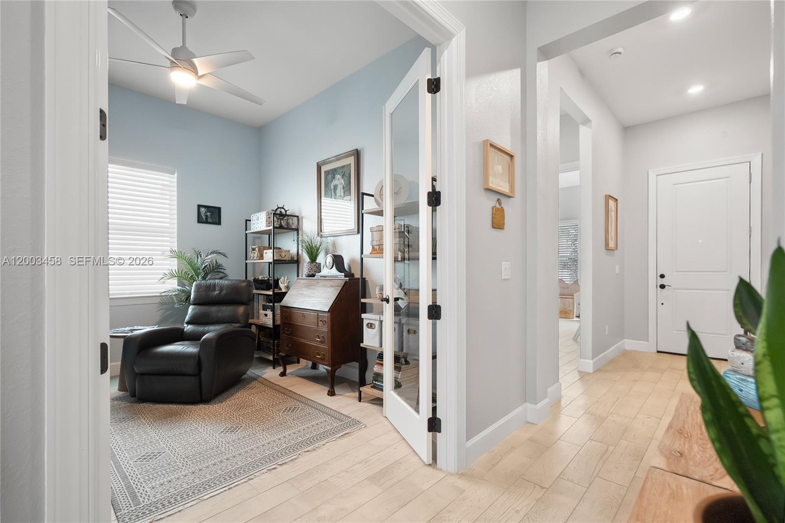 9734 Southwest Meridian Way Stuart, FL 34997 - Photo 25 of 48 a living room with furniture a desk and a chandelier