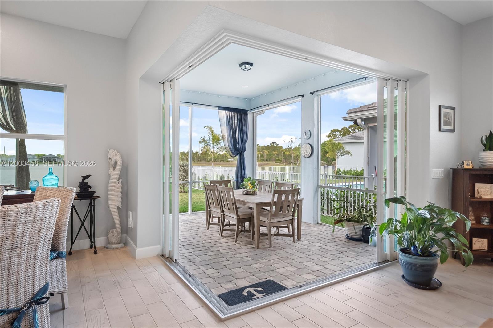 9734 Southwest Meridian Way Stuart, FL 34997 - Photo 33 of 48 a living room with furniture floor to ceiling window and wooden floor