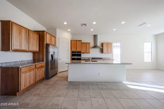 a large kitchen with granite countertop a large counter top stainless steel appliances and cabinets