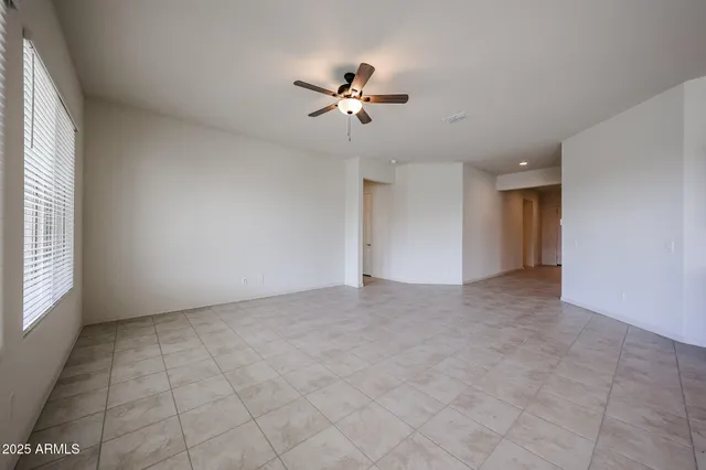 a view of a livingroom with a ceiling fan and window