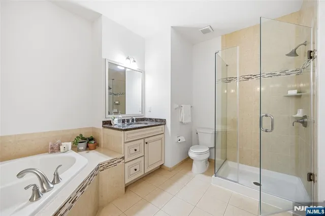 a spacious bathroom with a granite countertop sink a toilet and shower