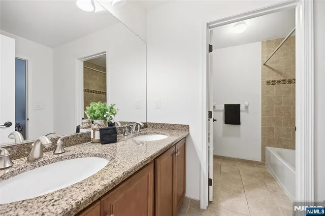 a bathroom with a granite countertop sink a mirror and shower