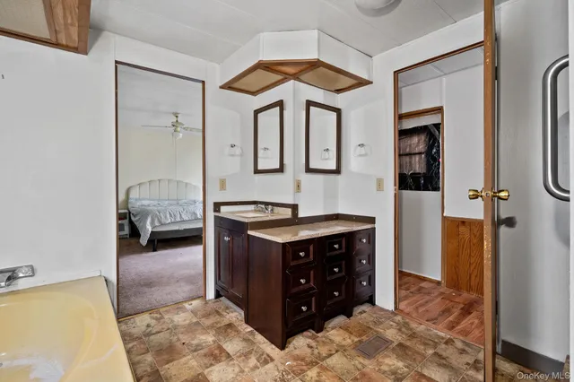 a spacious bathroom with a tub sink and mirror