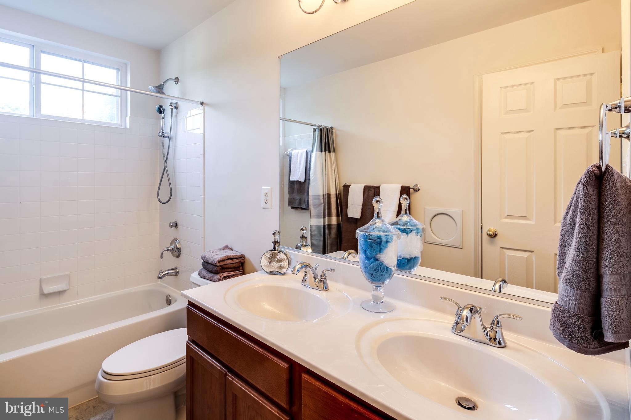 3614 Valley Road Ellicott City, MD 21042 - Photo 21 of 27 a bathroom with a granite countertop sink a toilet and shower