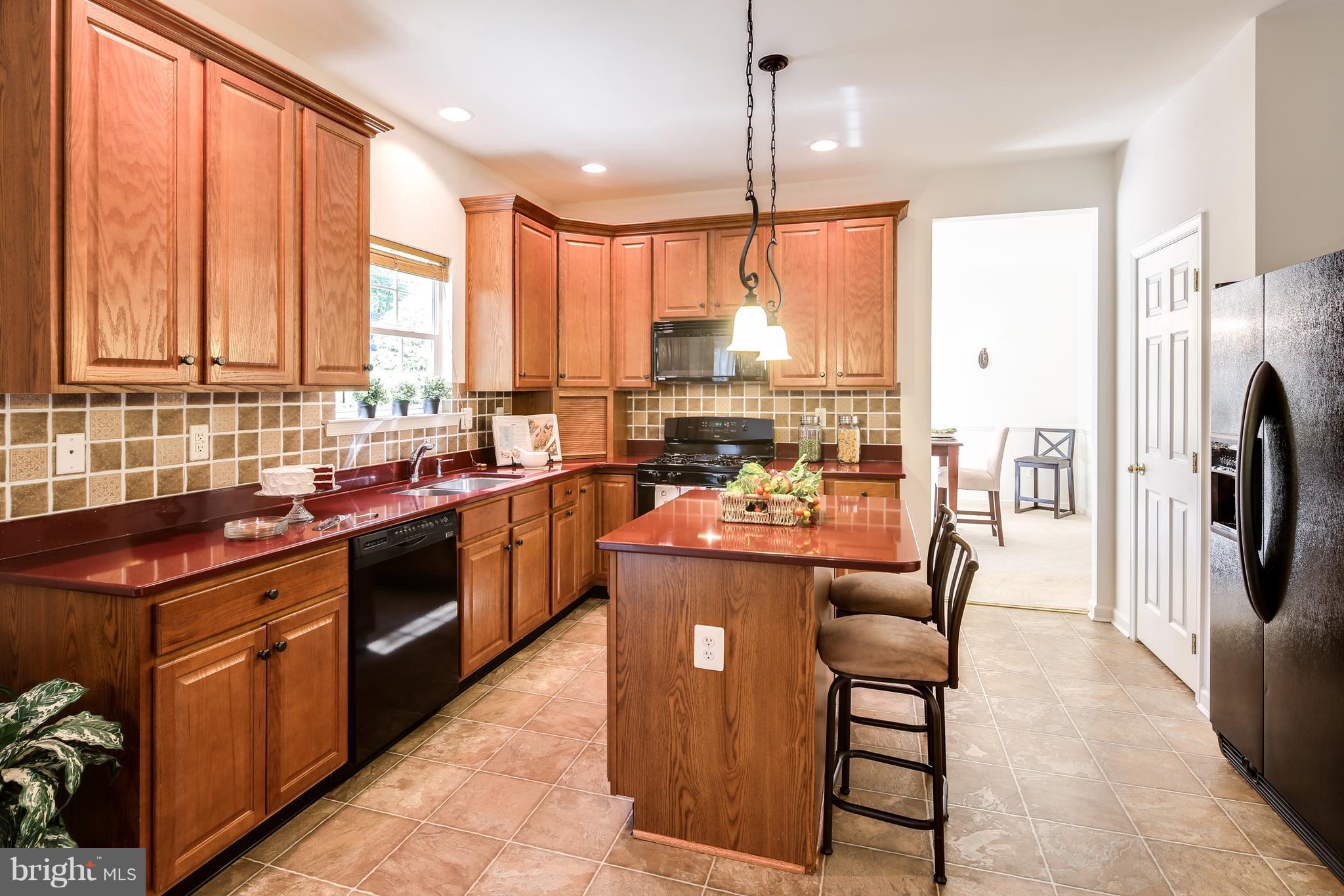3614 Valley Road Ellicott City, MD 21042 - Photo 8 of 27 a kitchen with stainless steel appliances granite countertop a stove top oven a refrigerator a sink and a dining table with wooden floor