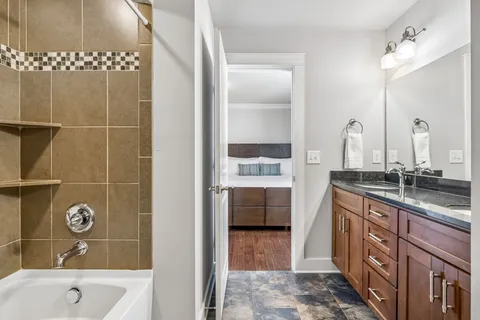 a bathroom with a tub sink and mirror