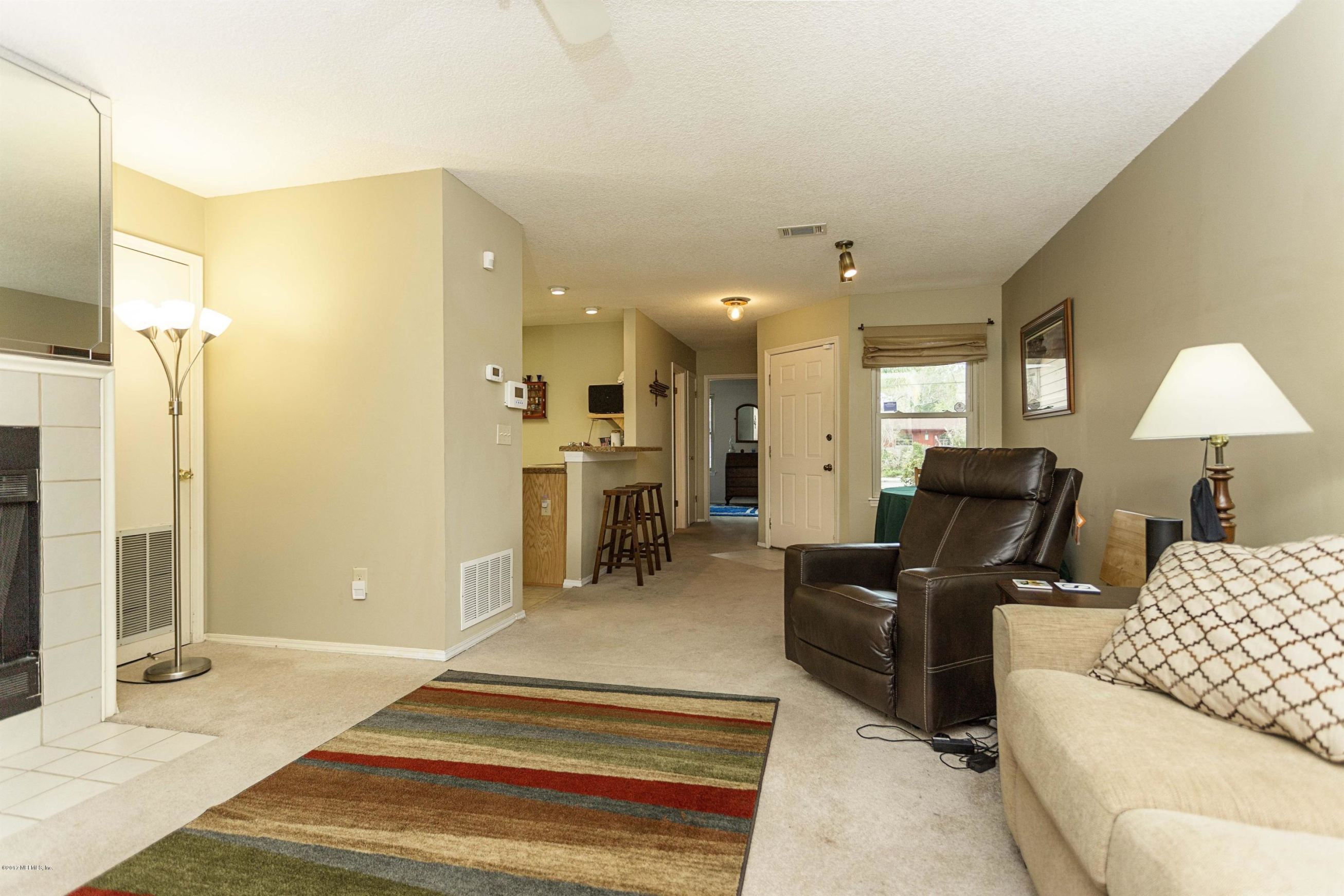 4775 Barnes Road South Jacksonville, FL 32207 - Photo 5 of 19 a living room with furniture a lamp and a chandelier