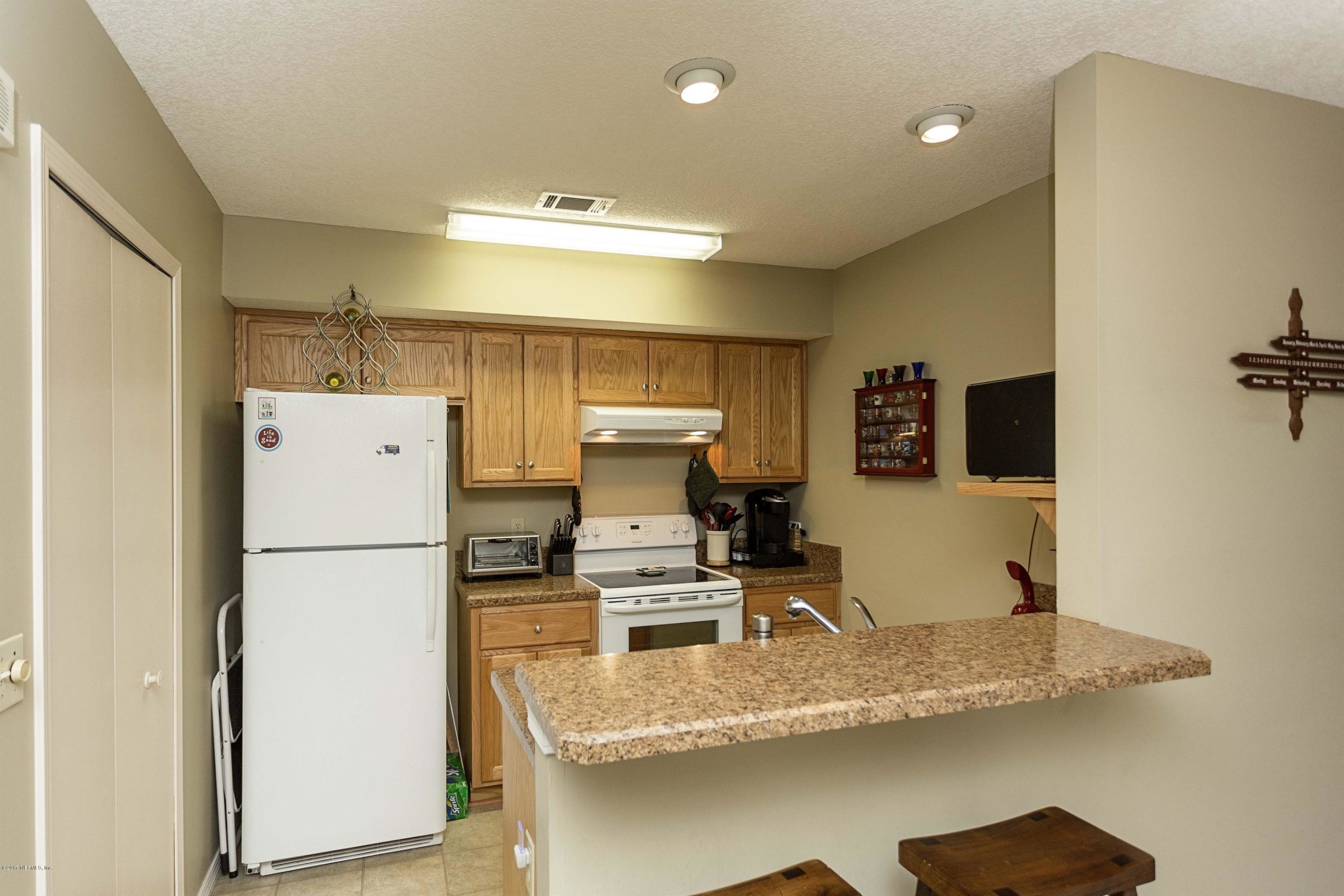 4775 Barnes Road South Jacksonville, FL 32207 - Photo 7 of 19 a kitchen with a refrigerator a stove and a sink with wooden floor