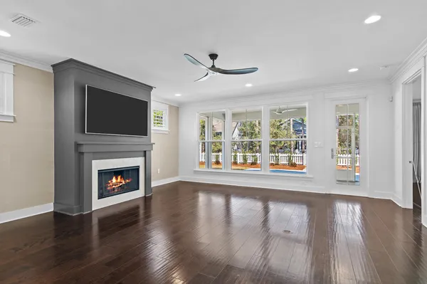 a living room with a fireplace a flat screen tv and wooden floor