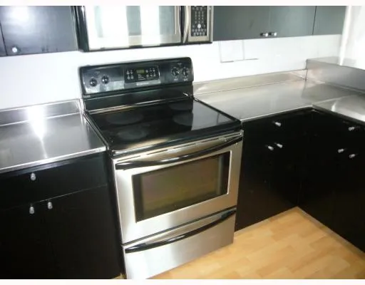a stove top oven sitting inside of a kitchen