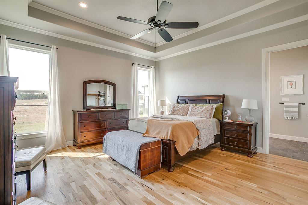 116 Aviara Ridge Road Poolville, TX 76487 - Photo 18 of 38 a bedroom with a bed couches and wooden floor