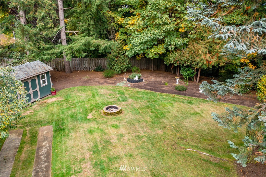 20915 West Richmond Road Bothell, WA 98021 - Photo 22 of 26 a view of a backyard with table and chairs and wooden fence