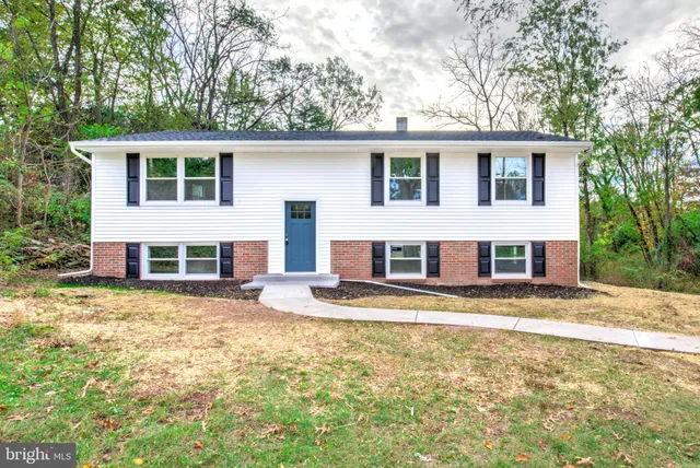 a view of a yard in front of a house with large tree