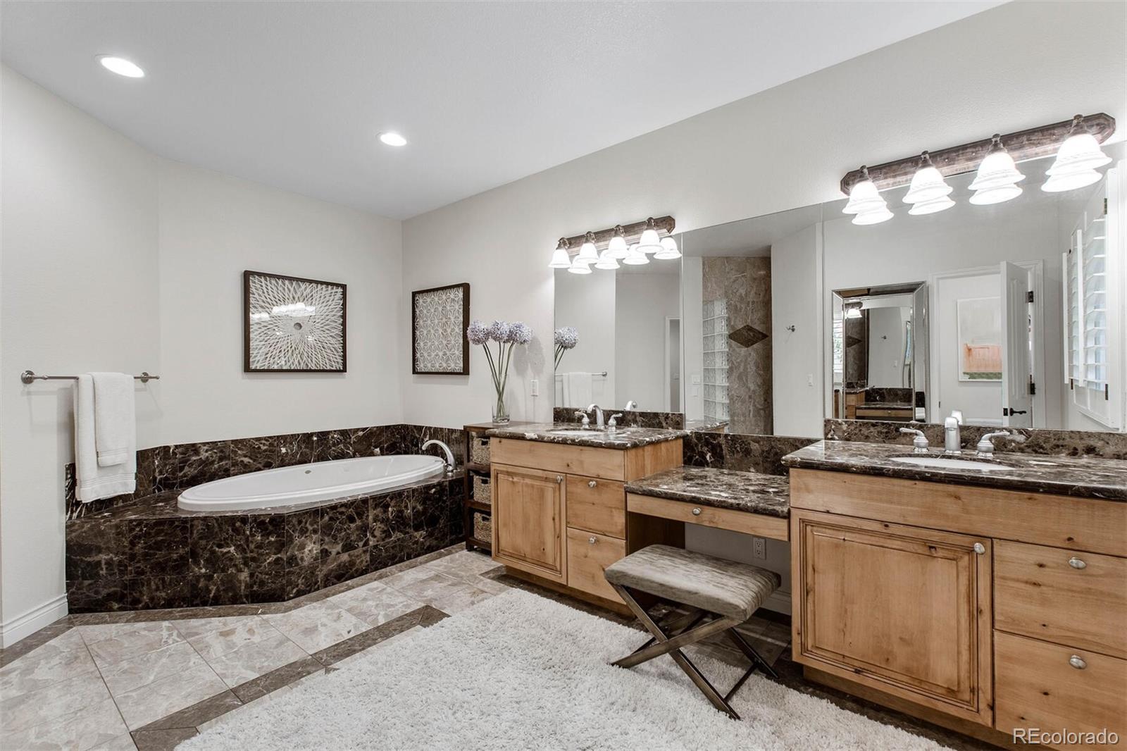 167 Monroe Street Denver, CO 80206 - Photo 19 of 39 a spacious en suite bathroom with a double vanity sink a mirror and a bathtub