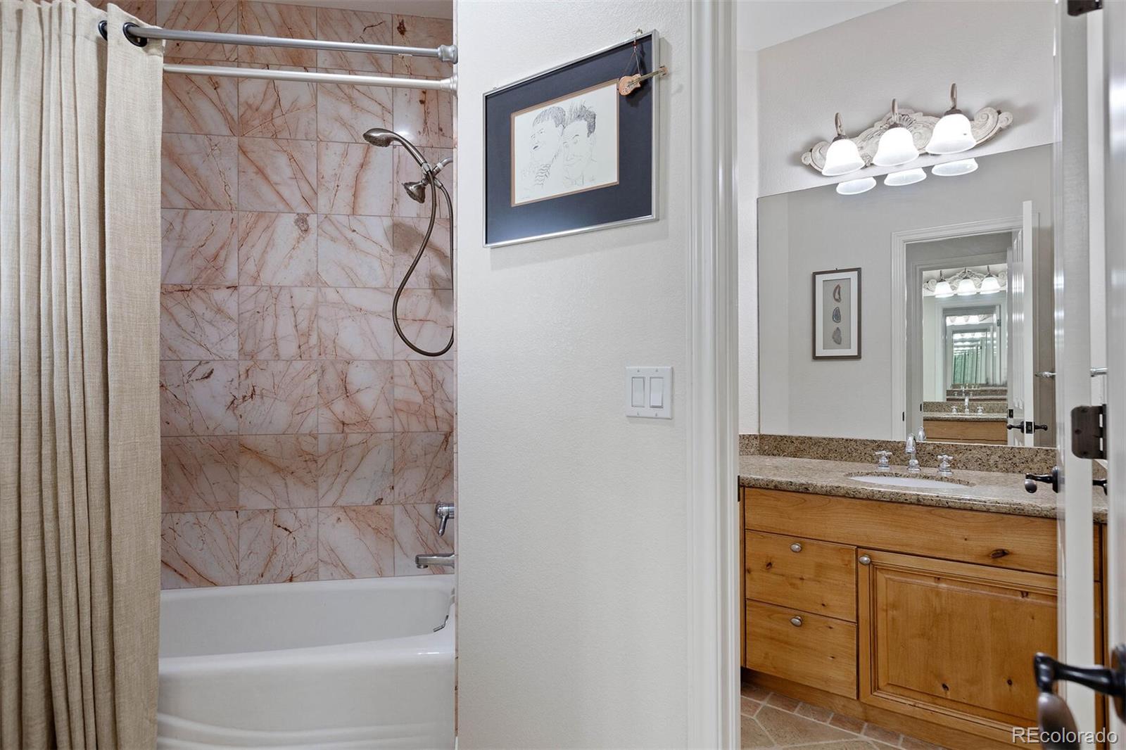 167 Monroe Street Denver, CO 80206 - Photo 23 of 39 a bathroom with a granite countertop sink a mirror a shower and a bathtub