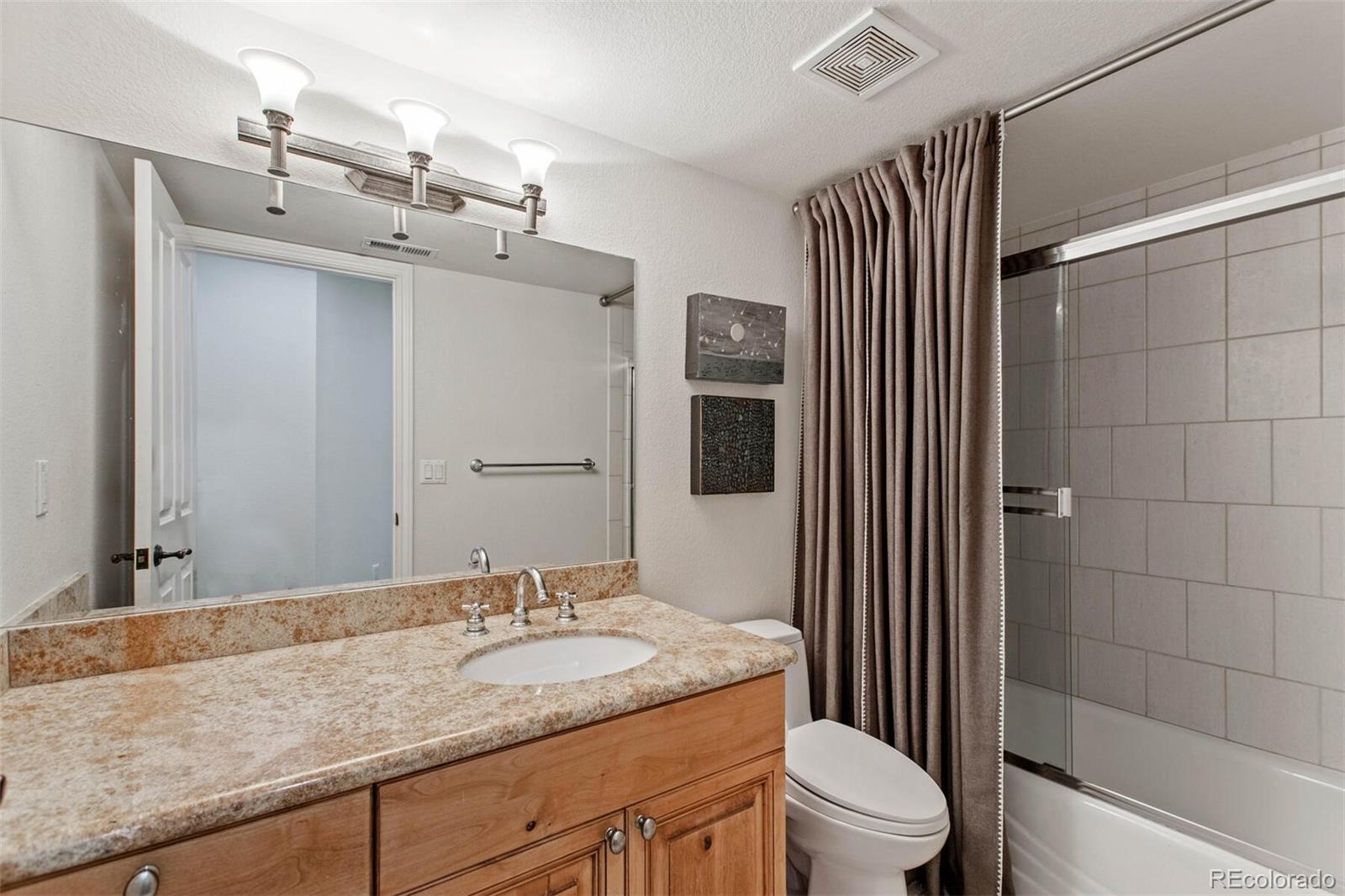 167 Monroe Street Denver, CO 80206 - Photo 28 of 39 a bathroom with a granite countertop sink toilet and shower