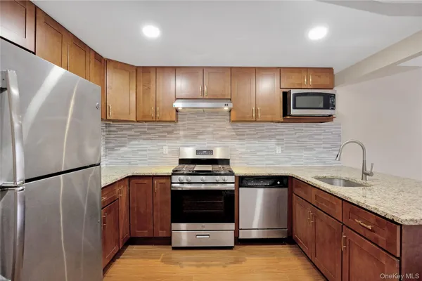 a kitchen with stainless steel appliances granite countertop a stove a refrigerator and a sink