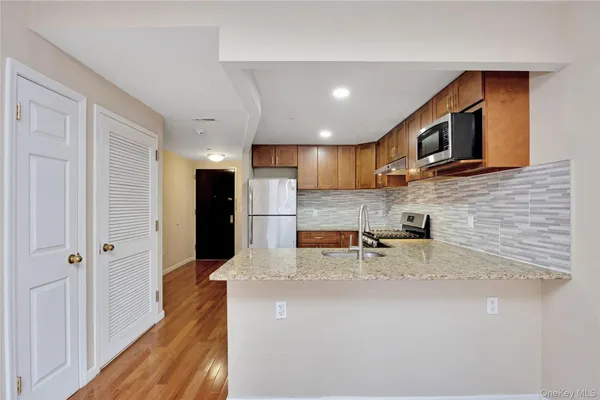 a kitchen with stainless steel appliances granite countertop a sink refrigerator and microwave