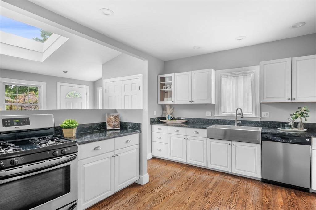 8 Baker Avenue Beverly, MA 01915 - Photo 2 of 40 a kitchen with stainless steel appliances granite countertop a stove a sink dishwasher and white cabinets with wooden floor