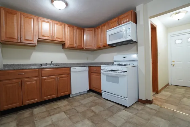 a kitchen with granite countertop cabinets stainless steel appliances and a sink