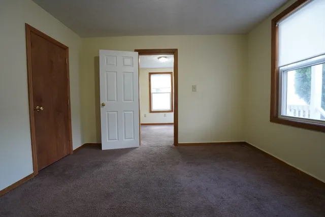 an empty room with windows and closet