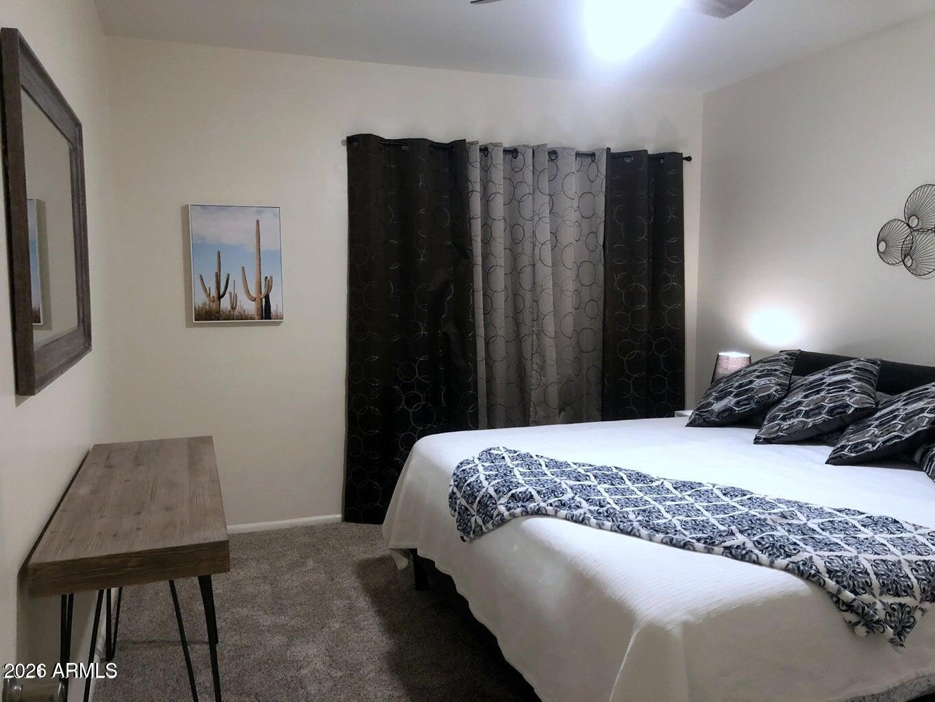 3242 East Camelback Road, Unit 104 Phoenix, AZ 85018 - Photo 16 of 19 a bedroom with a bed a table and a chair