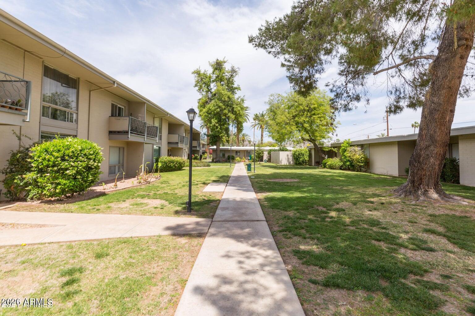 3242 East Camelback Road, Unit 104 Phoenix, AZ 85018 - Photo 17 of 19 a view of a brick house with a yard