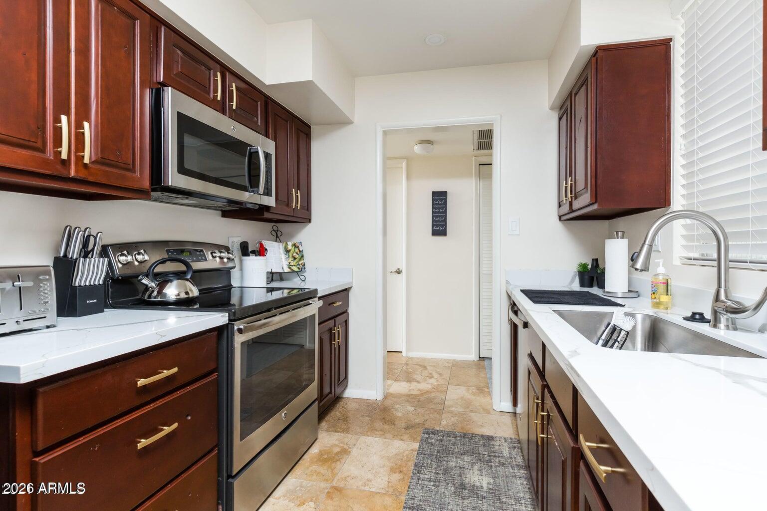 3242 East Camelback Road, Unit 104 Phoenix, AZ 85018 - Photo 2 of 19 a kitchen with a sink stove and microwave