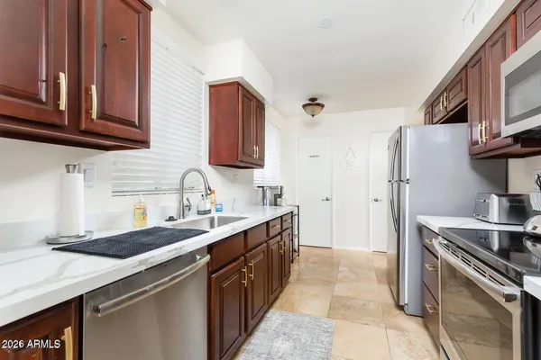 a kitchen with stainless steel appliances granite countertop a sink stove and refrigerator